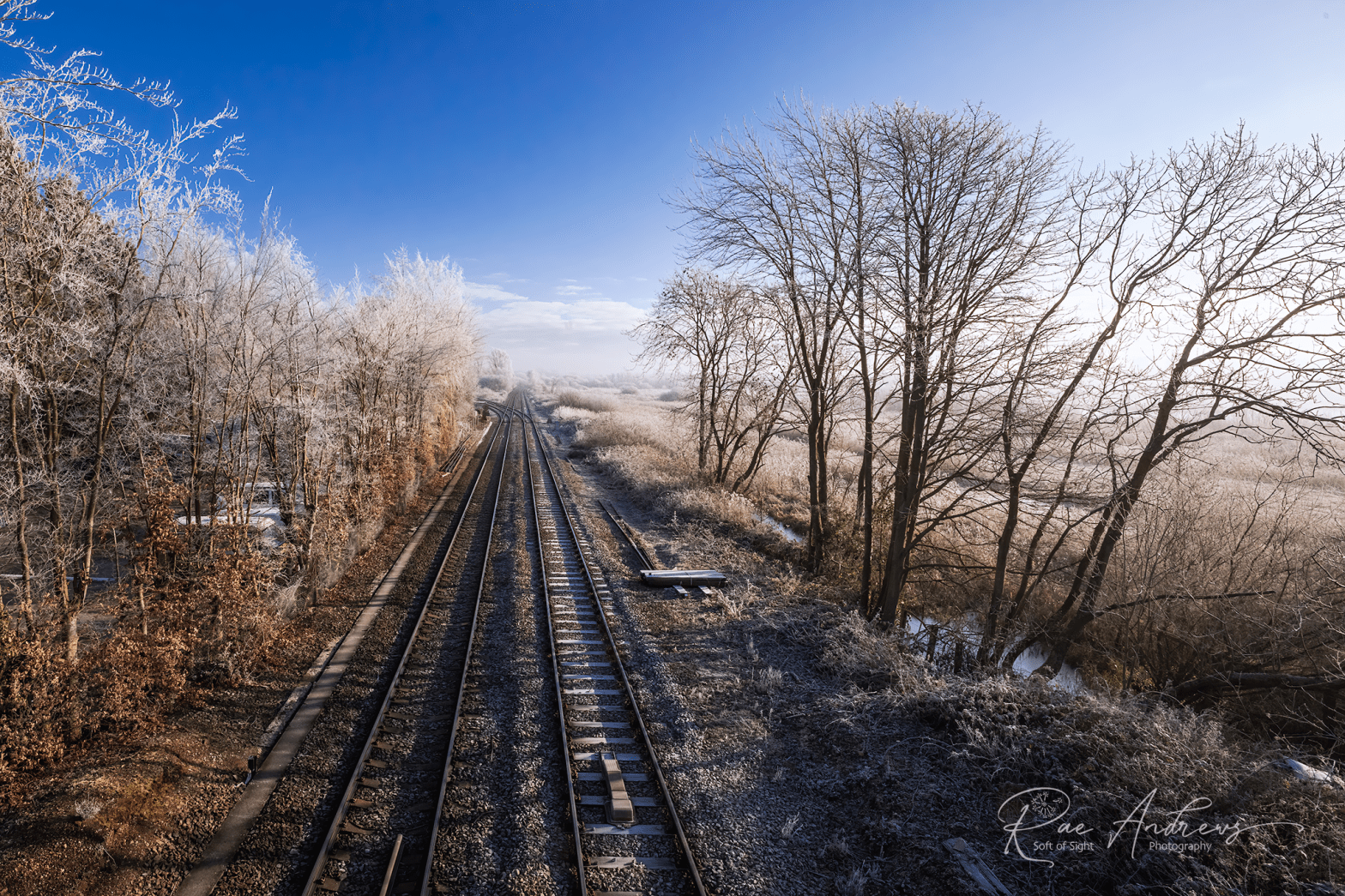A view from a bridge over railway tracks on a crisp winter's morning.