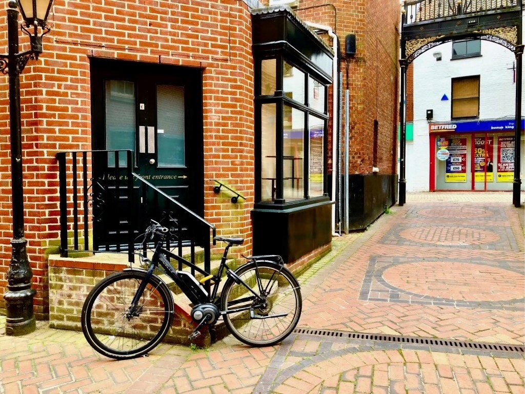 Photograph of a newly renovated mews, with a black bicycle leaning against iron railings.